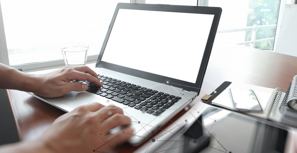 Close up of business man hand working on blank screen laptop computer with social network diagram on wooden desk as concept